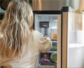 Woman taking the temperature of refridgerator