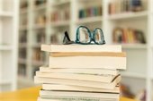 stack of books with glasses on top
