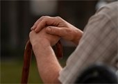 Older gentleman hands holding a cane