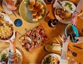 People passing food around a table